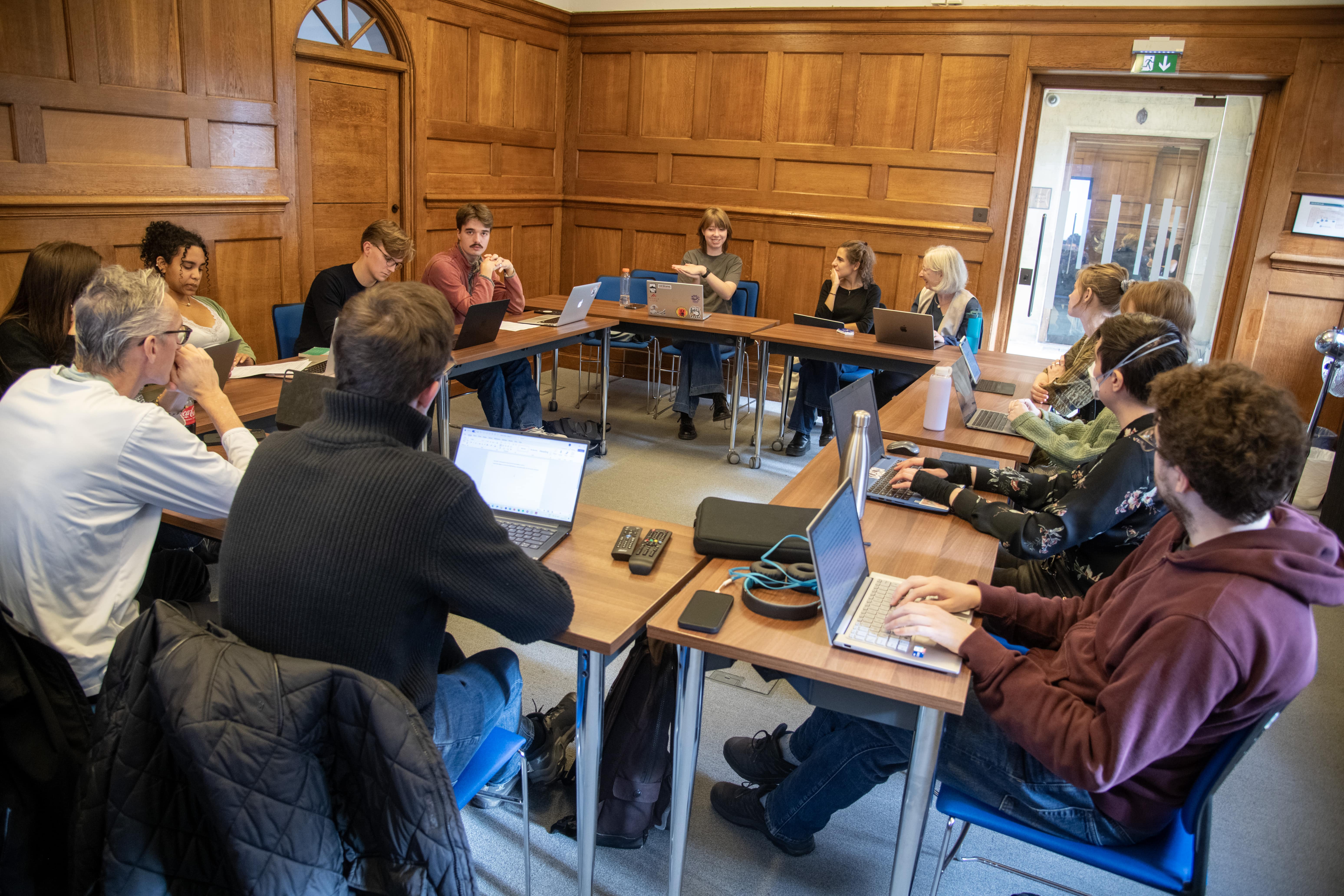 Students sat around a table with laptops